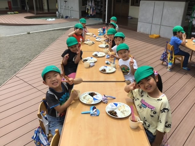 宝珠保育園外で給食を食べる子どもたち